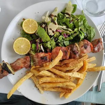 Chicken souvlaki with fried potatoes and green salad